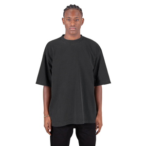 Shakawear Garment Dye Drop Shoulder Tee, made from 100% USA Cotton, with a heavyweight construction of 7.5oz (255/265 GSM). A notice highlights the unique garment dye process, ensuring each shirt boasts slight shade variations, enhancing its individuality and character.